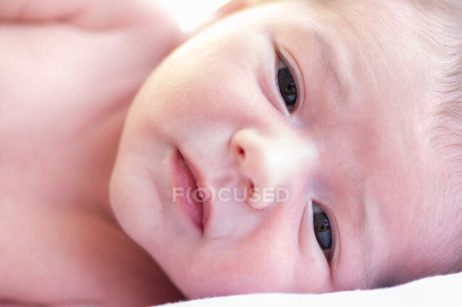 Adorable naked in infant sweetly lying on soft bed at home — Stock Photo