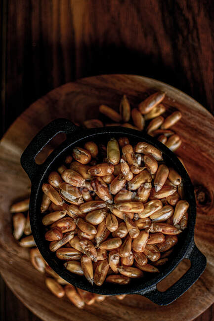 Вид зверху купа зерна зернових у мисці, розміщеній на дерев'яному столі на кухні — стокове фото