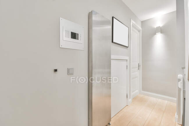 Interior design del corridoio con pareti bianche con lampada e foto mockup e pavimento in parquet chiaro in casa moderna in stile loft — Foto stock