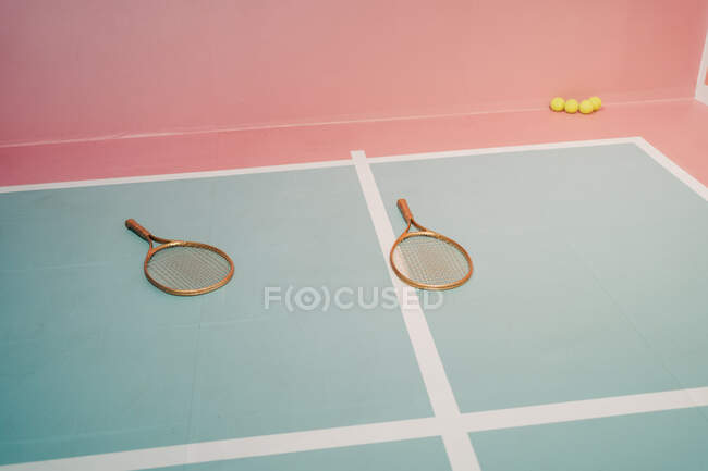 Креативный дизайн теннисных ракеток против маленьких мячей на спортивной площадке с разметкой линий — стоковое фото