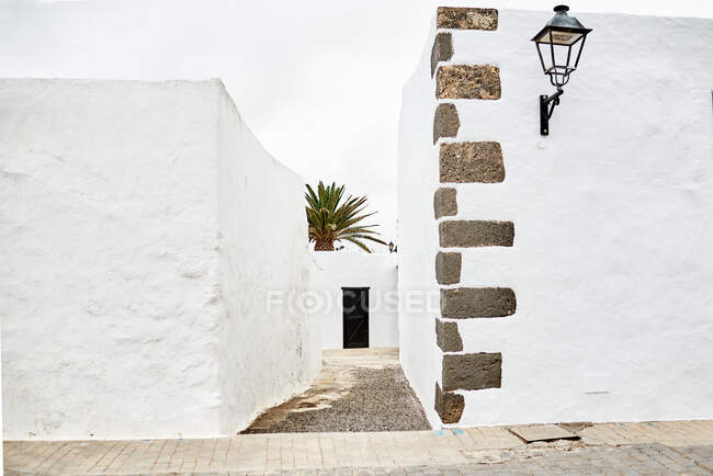Caminho estreito entre as paredes da casa branca no dia de verão na cidade de Fuerteventura, Espanha — Fotografia de Stock