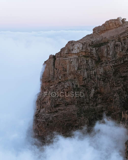 Ефектні пейзажі скелястої місцевості в високогір'ї в оточенні густих хмар на заході сонця — стокове фото
