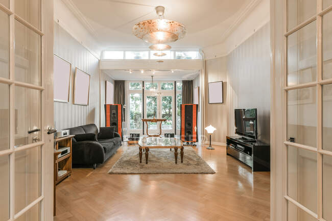Интерьер современной просторной гостиной со стерео системой и удобной мебелью в новой квартире — стоковое фото