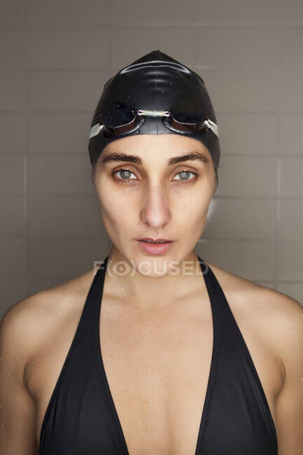 Porträt der schönen jungen Schwimmerin mit schwarzem Badehut und Schwimmbrille — Stockfoto