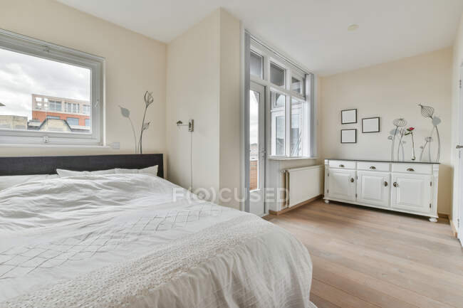 Moderner Loft-Stil Home Interior Design von geräumigen hellen Schlafzimmer mit Queen-Size-Bett und Schrank mit dekorativen Artikeln — Stockfoto