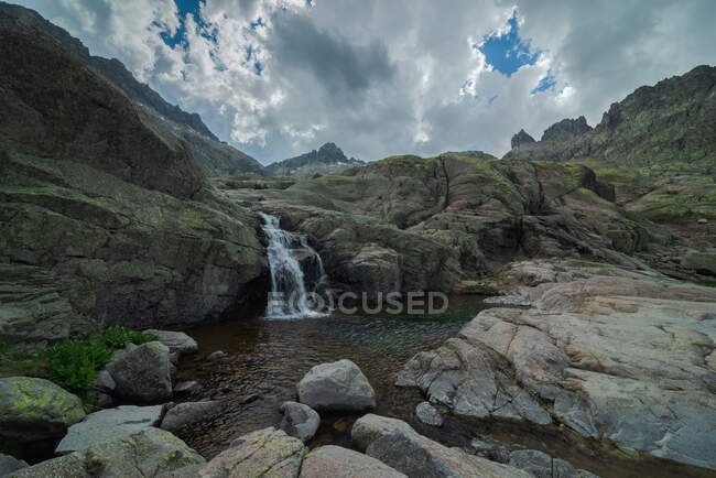 Vue panoramique de la Sierra de Gredos avec cascade et étang sous un ciel nuageux — Photo de stock