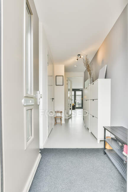 Перспективный вид на коридор с минималистской белой мебелью и дизайном интерьера в современном лофт-стиле квартиры — стоковое фото