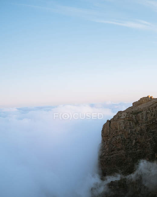Ефектні пейзажі скелястої місцевості в високогір'ї в оточенні густих хмар на заході сонця — стокове фото