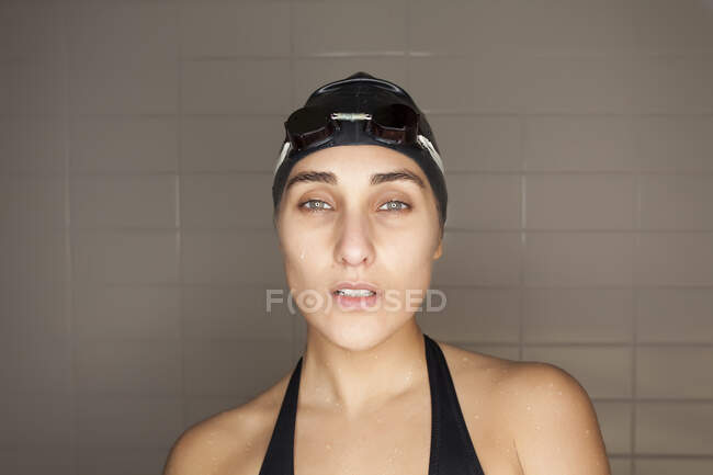 Retrato de bela jovem nadadora com chapéu de banho preto e óculos de natação — Fotografia de Stock