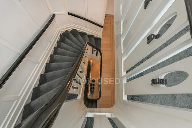 D'en haut de l'escalier en colimaçon blanc dans une maison résidentielle contemporaine conçue dans un style minimal — Photo de stock