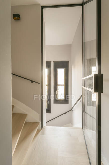 Minimalistisches Interieur eines modernen Hauses mit Treppe und Glastüren am Tag — Stockfoto