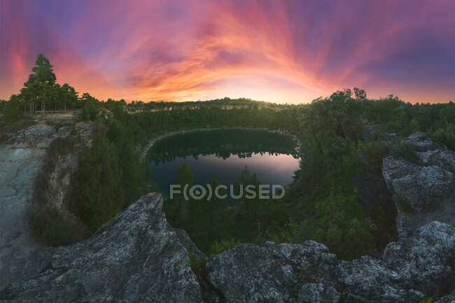 Vue pittoresque du lagon reflétant les arbres poussant sur les monts sous le soleil couchant à Cuenca Espagne — Photo de stock