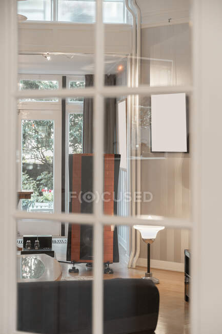 Через скляні двері вид сучасної вітальні зі стереосистемою в квартирі — стокове фото