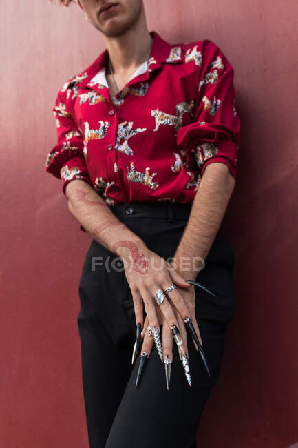 Crop unrecognizable trendy homosexual man with tattoo in form of snake and manicure on brown background — Stock Photo