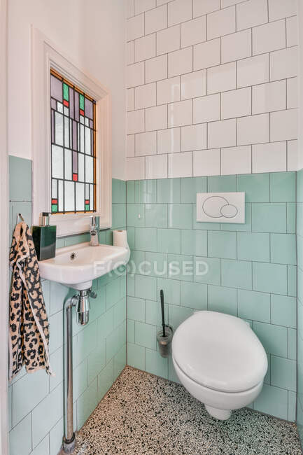 Стильний інтер'єр ванної кімнати з білою керамічною раковиною і плиткою стіни і встановленим туалетом в мінімальному стилі — стокове фото