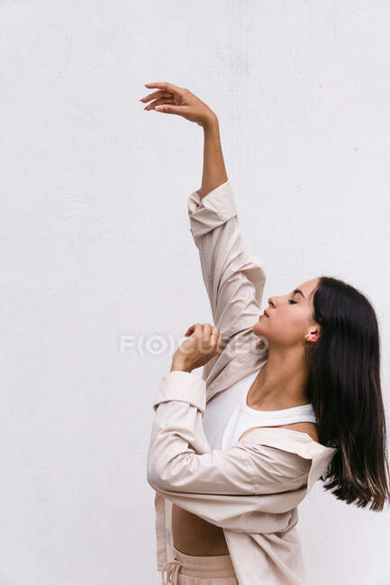 Talentosa bailarina contemporánea moviéndose y bailando cerca de la pared blanca en el área urbana de la ciudad - foto de stock