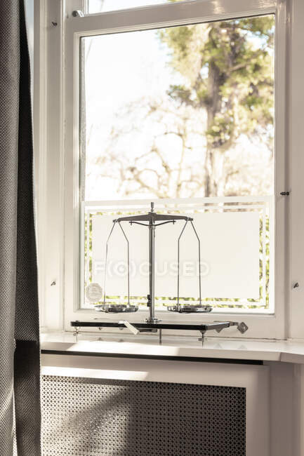 Modern weighing scale placed on white windowsill in flat with sunlight at daytime — Stock Photo