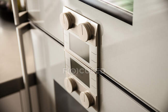 Enfoque selectivo en el panel de control con interruptores y pantalla en el horno eléctrico en la cocina casera moderna - foto de stock