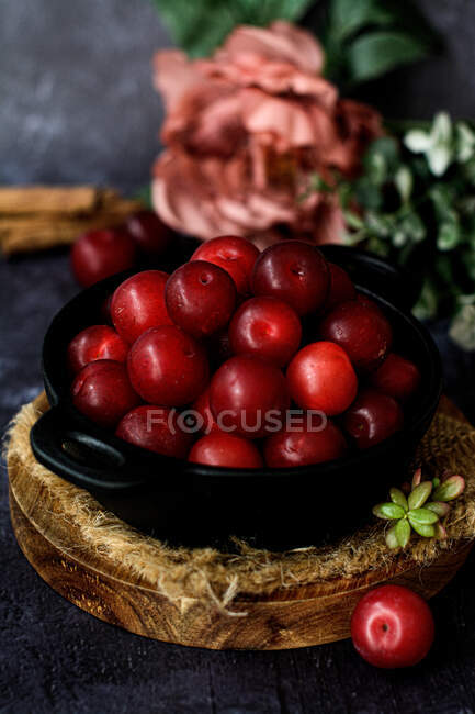 Cuenco con ciruelas dulces frescas servidas sobre mesa negra - foto de stock