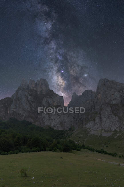 Scenery view of starry sky with galaxy and interstellar gas over magnificent ridges — Stock Photo