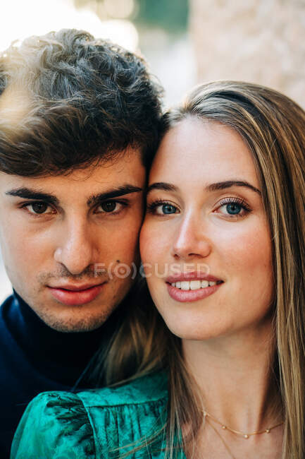 Young stylish couple standing close to each other in city street and smiling — Stock Photo