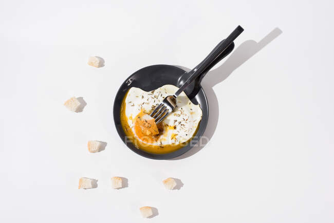 Pedaços de pão servidos na mesa branca com ovo frito apetitoso na frigideira com garfo — Fotografia de Stock