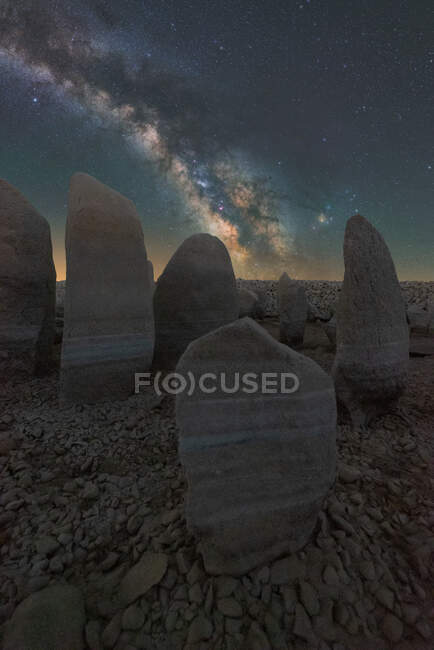 Vista pitoresca de Stonehenge espanhol em terreno acidentado sob o céu por do sol com galáxia em Cáceres Espanha — Fotografia de Stock
