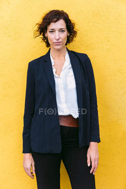 Самозабезпечена елегантна жінка в офіційному вбранні, що стоїть на камеру — стокове фото