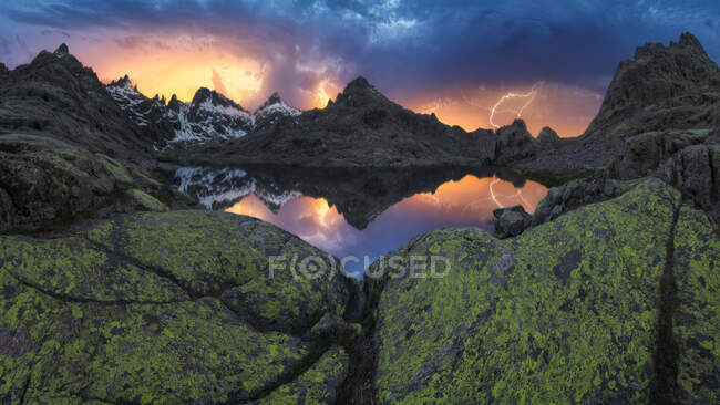 Vista del paisaje de Sierra de Gredos con musgo y estanque bajo el cielo nublado de colores en el crepúsculo - foto de stock