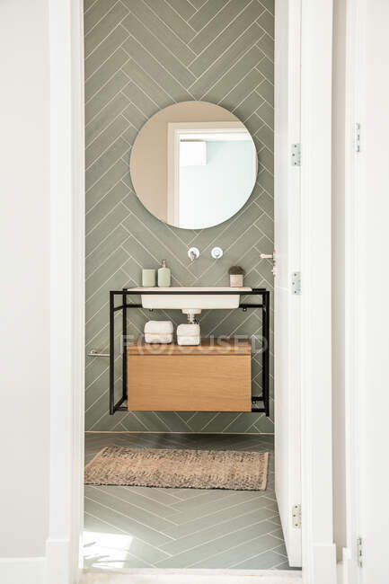 Lavabo et toilettes en céramique blanche près de la douche et de la baignoire dans une salle de bain moderne avec des murs vert pastel — Photo de stock