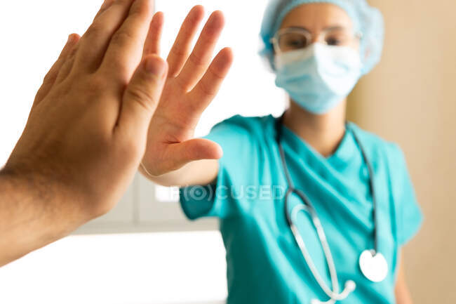 Crop unrecognizable male medic giving high five to female colleague while working in hospital — Stock Photo