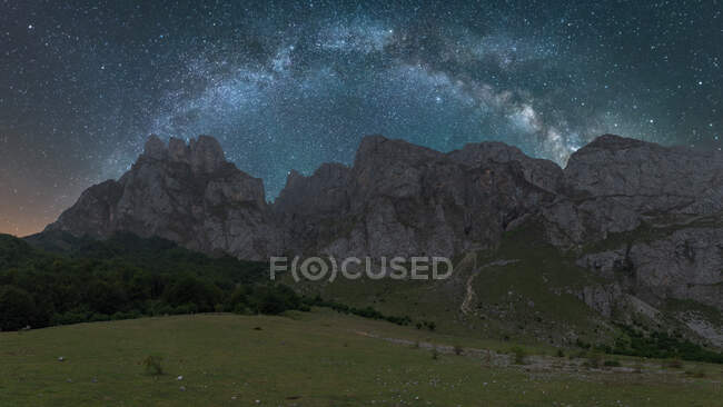 Scenery view of starry sky with galaxy and interstellar gas over magnificent ridges at sunset — Stock Photo