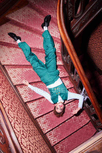 Von oben ein ausdrucksstarker männlicher Schauspieler, der auf einer Treppe liegt und vorgibt, während der Vorstellung tot zu sein — Stockfoto