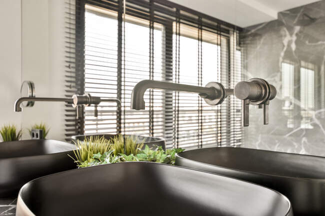 Стильний дизайн інтер'єру розкішної просторої ванної кімнати з мармуровою плиткою, обставленою подвійним умивальником і темно-коричневим дерев'яним шафою під великим дзеркалом в сучасній квартирі — стокове фото