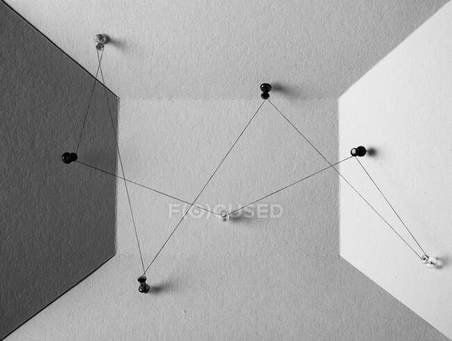 Чорно-білий вид на нитку між шпильками, що представляють концепцію технологічної системи в управлінні бізнесом — стокове фото