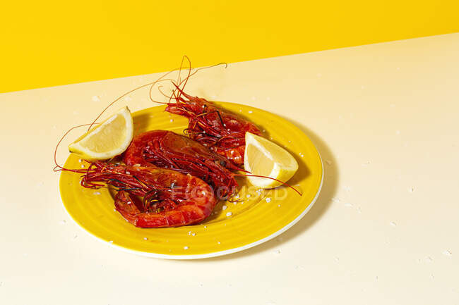 Frutos do mar saborosos de camarões vermelhos cozidos com fatias de limão fresco e sal grosso em dois fundo de cor — Fotografia de Stock