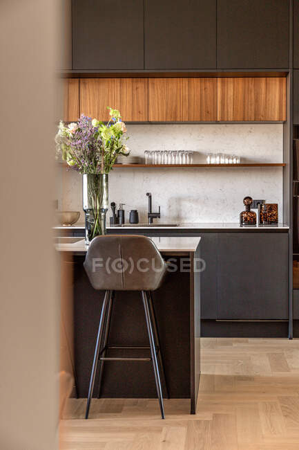 Interior da cozinha moderna com móveis cinza escuro e plantas envasadas verdes no apartamento em estilo mínimo — Fotografia de Stock