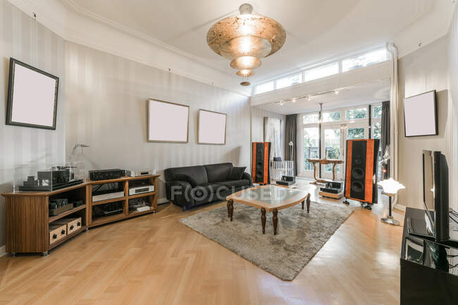 Interior do espaçoso salão contemporâneo com sistema estéreo e mobiliário confortável em novo apartamento — Fotografia de Stock