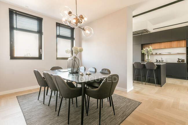 Intérieur de la salle à manger avec table noire et chaises dans un appartement contemporain conçu dans un style minimal — Photo de stock
