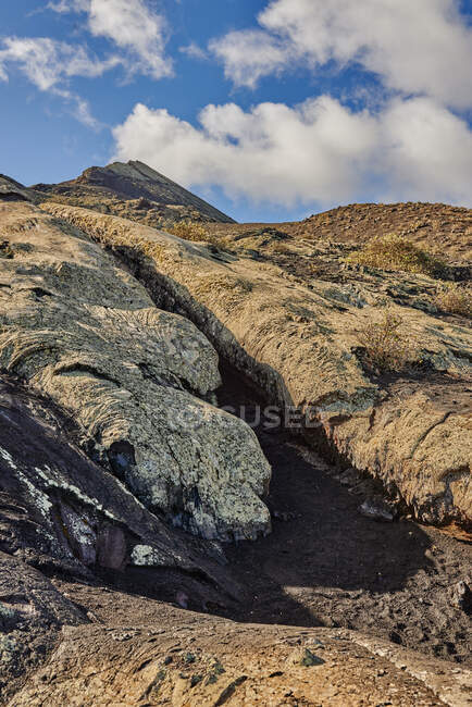 Raue steinige Oberfläche in der Nähe von Pfaden an bewölkten Sommertagen in der Natur von Fuerteventura, Spanien — Stockfoto