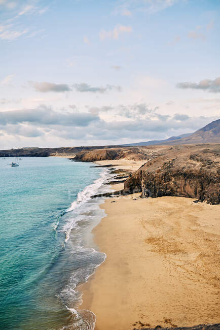 Беспилотный вид песчаного пляжа с чистой бирюзовой водой в солнечный летний день в Фуэртевентуре, Испания — стоковое фото