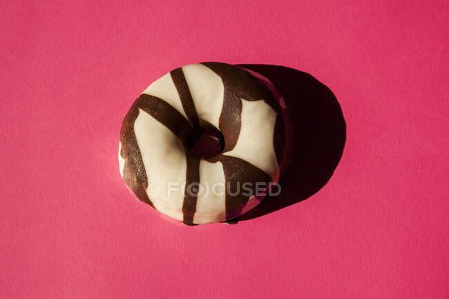 Donuts brancos revestidos oreo pedaços de biscoito de chocolate no fundo rosa — Fotografia de Stock