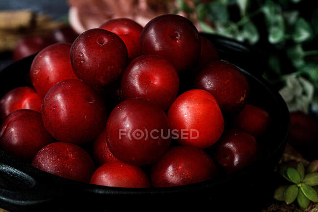Ciotola con prugne dolci fresche servita sul tavolo nero — Foto stock
