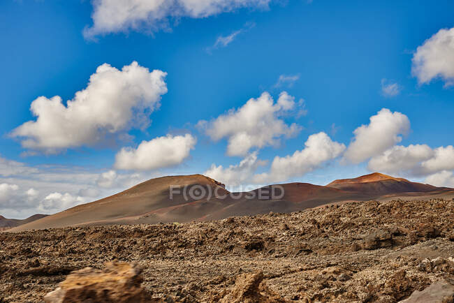 Weitwinkelblick auf felsige, trockene Hügel im Hochland gegen bewölkten Himmel im Sommer auf Fuerteventura, Spanien — Stockfoto