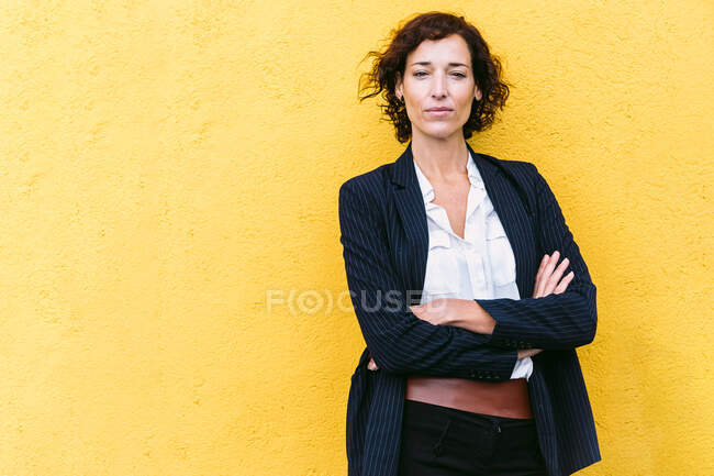 Самозабезпечена елегантна жінка в офіційному вбранні, що стоїть на камеру — стокове фото