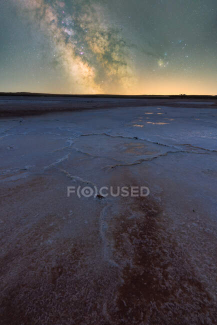 Cenário espetacular de estrelas brilhantes da Via Láctea no céu noturno sobre a lagoa de sal seco em longa exposição — Fotografia de Stock