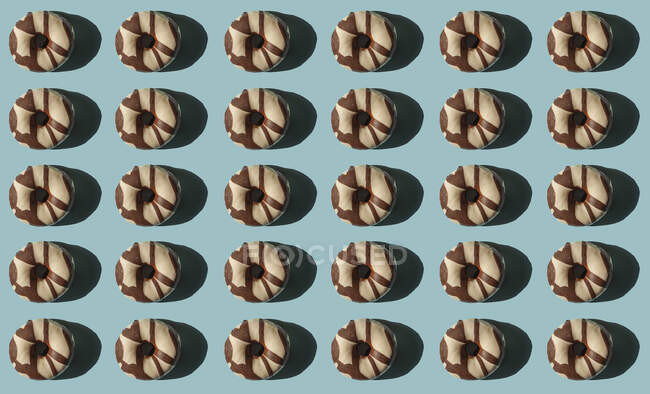 Top view of many donuts covered with chocolate black and white on blue background — Stock Photo