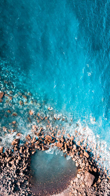 Vista aerea di incredibile mare blu e spiaggia rocciosa con pietre nella giornata di sole — Foto stock
