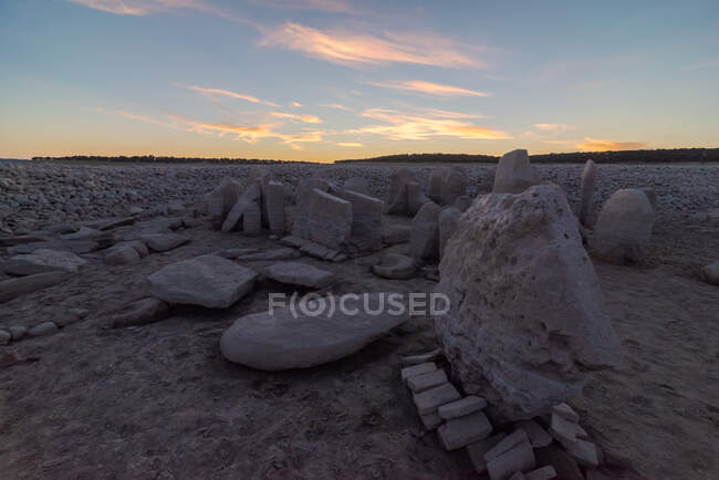 Dolmen de Guadalperal con antiguos monumentos megalíticos en tierra firme bajo el sol en pleno crepúsculo en Cáceres España - foto de stock