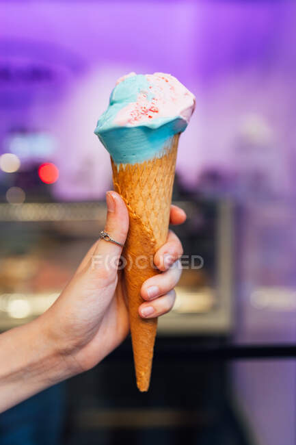 Jovem anônima com delicioso gelato em cone de waffle com fundo borrão na rua — Fotografia de Stock